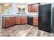 Cozy kitchen with wooden cabinets, laminate counters, black appliances, and wood-look flooring at 4350 Annlette Dr, Lawrenceville, GA 30044