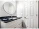 Stylish bathroom with a modern mirror, attractive vanity and black countertop at 13995 Mariners Cv, Alpharetta, GA 30005