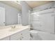 Bathroom featuring tiled shower over tub and white vanity with gold hardware at 13995 Mariners Cv, Alpharetta, GA 30005