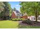 Beautiful brick home featuring a landscaped yard, manicured bushes, and a lovely, shady tree at 13995 Mariners Cv, Alpharetta, GA 30005