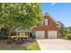 Charming two-story brick home with a well-maintained lawn, mature tree and a two-car garage at 13995 Mariners Cv, Alpharetta, GA 30005