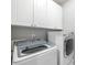 Convenient laundry room with front loading machines and ample cabinet storage at 13995 Mariners Cv, Alpharetta, GA 30005