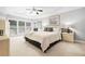 Spacious primary bedroom with a tray ceiling, neutral walls, and a sitting area by the windows at 13995 Mariners Cv, Alpharetta, GA 30005