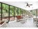 Relaxing sunroom with large windows and tile flooring with a ceiling fan at 13995 Mariners Cv, Alpharetta, GA 30005