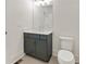Elegant bathroom vanity with gray cabinetry, white countertop, modern fixtures and a toilet with gray tile floor at 2410 Glade Overlook, Cumming, GA 30041