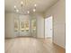 Dining room with bay windows, panelled walls, hardwood floors, and modern chandelier at 2410 Glade Overlook, Cumming, GA 30041
