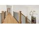 Bright hallway featuring hardwood floors, wood banister, and wrought iron spindles at 2410 Glade Overlook, Cumming, GA 30041