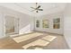 Serene main bedroom with hardwood floors, a tray ceiling with fan and lots of natural light from large windows at 2410 Glade Overlook, Cumming, GA 30041