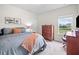 Well-lit bedroom with neutral decor, a large window, and a wooden dresser for ample storage at 31 Village Trce, Rydal, GA 30171