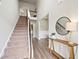 Bright entryway featuring hardwood floors, staircase, and decorative round mirror at 31 Village Trce, Rydal, GA 30171