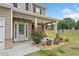 Inviting front porch features a brick accent, colorful landscaping, and a cozy entrance at 31 Village Trce, Rydal, GA 30171