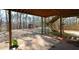 Covered patio leading to backyard with wooden stairs, outbuilding, and stone retaining wall at 6865 Cowan Mill Rd, Winston, GA 30187