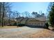 Traditional-style home features an attached three-car garage and covered porch nestled in a wooded setting at 6865 Cowan Mill Rd, Winston, GA 30187