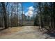 Long driveway leading to a house with a three-car garage and surrounded by trees in a secluded setting at 6865 Cowan Mill Rd, Winston, GA 30187
