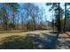 Secluded home with wooded landscape showing the three-car garage and covered porch in a tranquil setting at 6865 Cowan Mill Rd, Winston, GA 30187