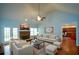 Light-filled living room features vaulted ceiling, stone fireplace, and hardwood floors overlooking the backyard at 6865 Cowan Mill Rd, Winston, GA 30187