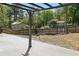 View of a backyard with concrete pad and a fire pit with perimeter seating. A wooden fence defines the yard at 2638 Lake Manor Cir, Duluth, GA 30096