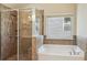 Bright bathroom featuring a separate shower, soaking tub, and tiled walls, creating a spa-like retreat at 2638 Lake Manor Cir, Duluth, GA 30096