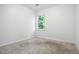 Neutral bedroom with a window providing natural light and neutral carpet at 2771 Kenwood Dr, Duluth, GA 30096