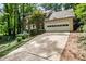 Brick home with attached garage and spacious driveway, surrounded by trees and landscaping at 2771 Kenwood Dr, Duluth, GA 30096