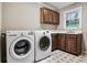 Well-equipped laundry room with modern washer and dryer units, with storage cabinets, and natural light at 2771 Kenwood Dr, Duluth, GA 30096