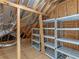 Unfinished attic showcasing wooden beams, insulation, and metal storage racks at 3905 Pointer Rd, Loganville, GA 30052