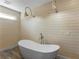 Bathroom features a free standing tub, horizontal wood paneling and sconce lighting at 3905 Pointer Rd, Loganville, GA 30052