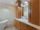 Bathroom features double vanity, sconce lighting, and free standing soaking tub at 3905 Pointer Rd, Loganville, GA 30052