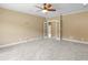 A bright, carpeted bedroom with a ceiling fan and a view into an adjacent room through glass-paneled doors at 3905 Pointer Rd, Loganville, GA 30052