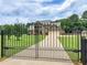 View of the gated driveway leading to the home with large lawn at 3905 Pointer Rd, Loganville, GA 30052
