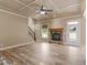 Spacious living room with fireplace, coffered ceiling, wood-look tile flooring, and staircase at 3905 Pointer Rd, Loganville, GA 30052