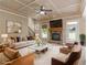 Staged living room with fireplace, coffered ceiling, wood-look tile flooring, and staircase at 3905 Pointer Rd, Loganville, GA 30052