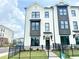 Modern townhome with white brick facade, black window trim, and manicured landscaping at 500 Healy Dr # 77, Cumming, GA 30040
