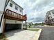 Exterior view of a white townhome featuring a private balcony, garage, and lush landscaping at 500 Healy Dr # 77, Cumming, GA 30040