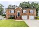 Beautiful two-story brick home with a well-manicured lawn and two-car garage at 6118 Arbor Links Rd, Lithonia, GA 30058
