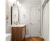 Bathroom with wood vanity, hardwood floors, decorative mirror, and shower with curtain at 1560 Heritage Trl, Roswell, GA 30075