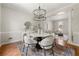 Open-concept dining room with hardwood floors, table and stylish chairs at 1560 Heritage Trl, Roswell, GA 30075