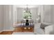 Bright dining room with hardwood floors, a round table, and large windows overlooking greenery at 1560 Heritage Trl, Roswell, GA 30075