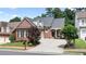 Charming brick home featuring a well-manicured lawn, mature trees, and a private driveway at 1560 Heritage Trl, Roswell, GA 30075
