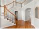 Spacious foyer showcasing hardwood floors, a staircase, and arched doorways for a grand entry at 1560 Heritage Trl, Roswell, GA 30075