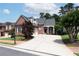 Charming brick home with a manicured front lawn, large driveway, and inviting front porch at 1560 Heritage Trl, Roswell, GA 30075