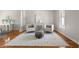 Elegant living room features hardwood floors, neutral tones, with 2 white upholstered chairs at 1560 Heritage Trl, Roswell, GA 30075