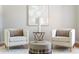Close up of the living room showcasing hardwood floors, neutral tones, and two white upholstered chairs at 1560 Heritage Trl, Roswell, GA 30075