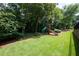Beautiful backyard view with a play structure amidst lush greenery at 1560 Heritage Trl, Roswell, GA 30075