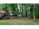 Large backyard featuring a deck, shed, and mature trees, providing ample space for outdoor activities and storage at 3657 Linda Dr, Loganville, GA 30052