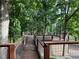 A wooden deck with metal railings surrounded by lush green trees at 3657 Linda Dr, Loganville, GA 30052