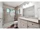 Tiled bathroom with glass shower, granite countertop, and white vanity at 3657 Linda Dr, Loganville, GA 30052