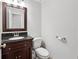 Half bath features elegant wood vanity with granite countertop and classic fixtures at 3657 Linda Dr, Loganville, GA 30052