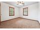 Bedroom with neutral carpet, wood trim, and two windows at 3657 Linda Dr, Loganville, GA 30052