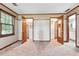 Carpeted bedroom featuring wood trim, two open closets with shelving and a window at 3657 Linda Dr, Loganville, GA 30052